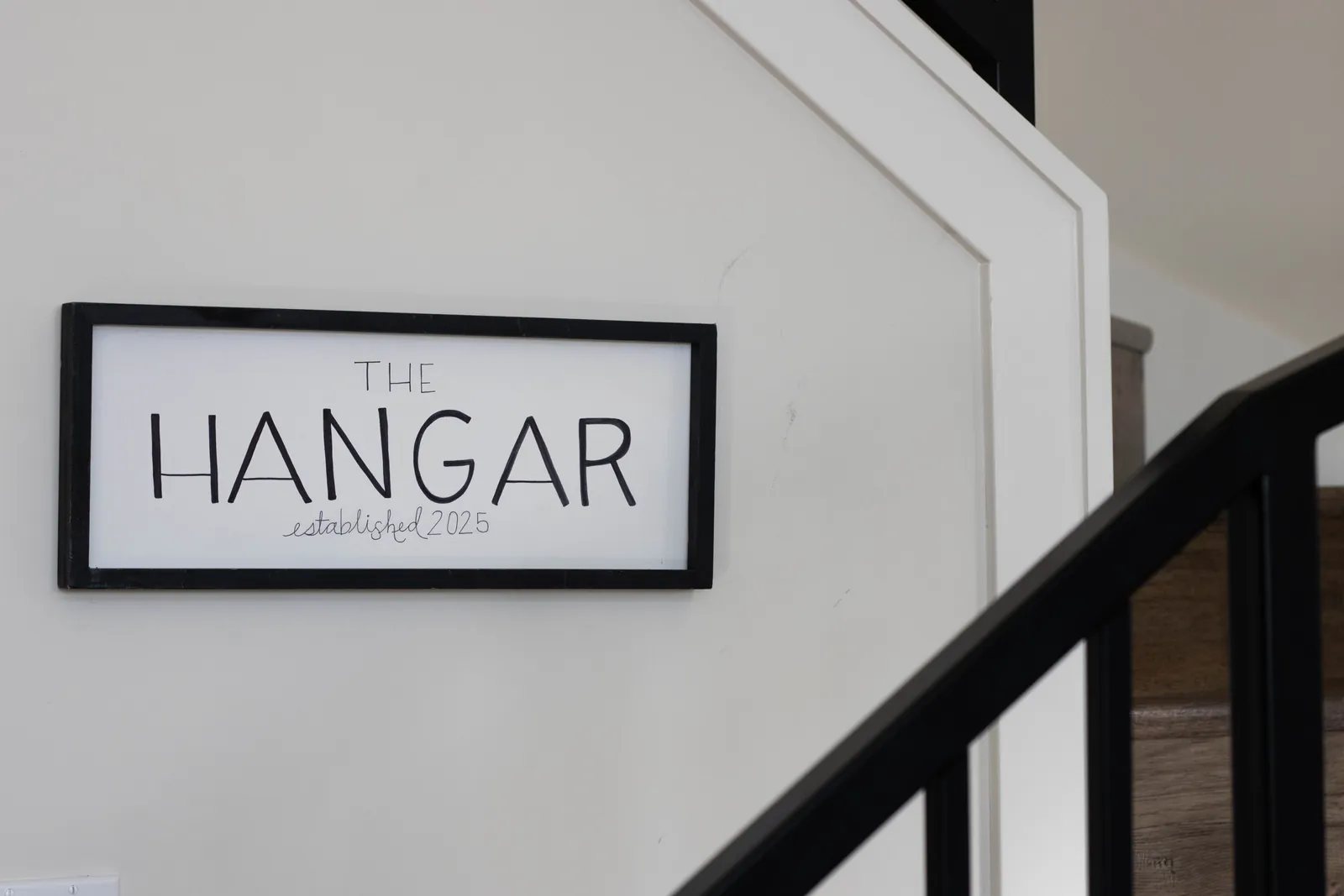 The Hangar — hand-lettered sign beside the stairway